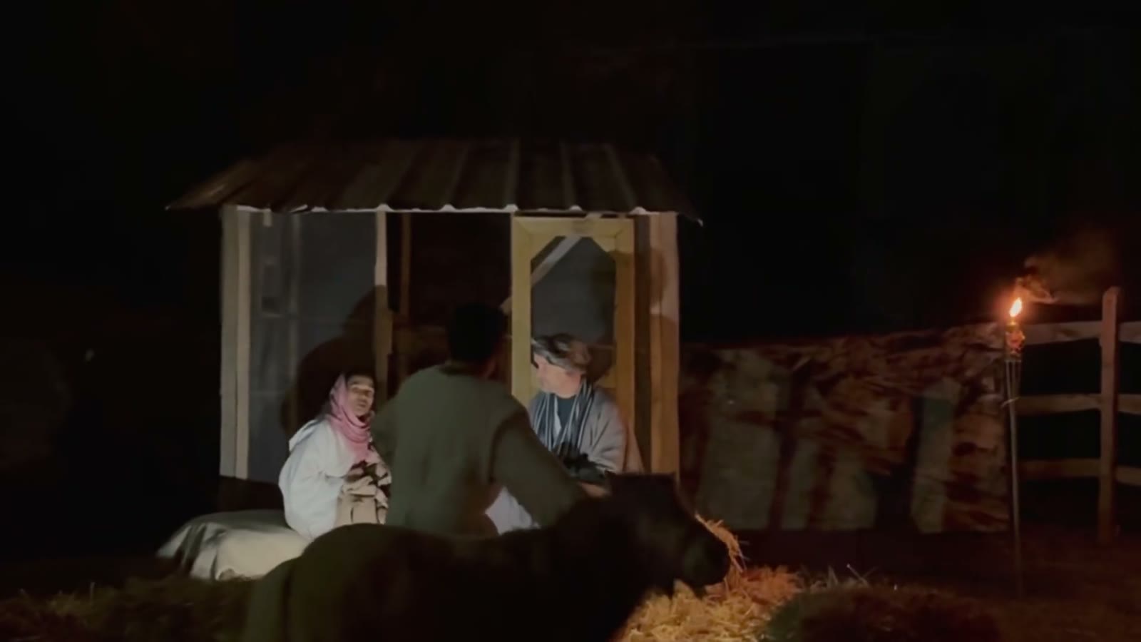 Torchlight falls on the stable where Mary and Joseph wait