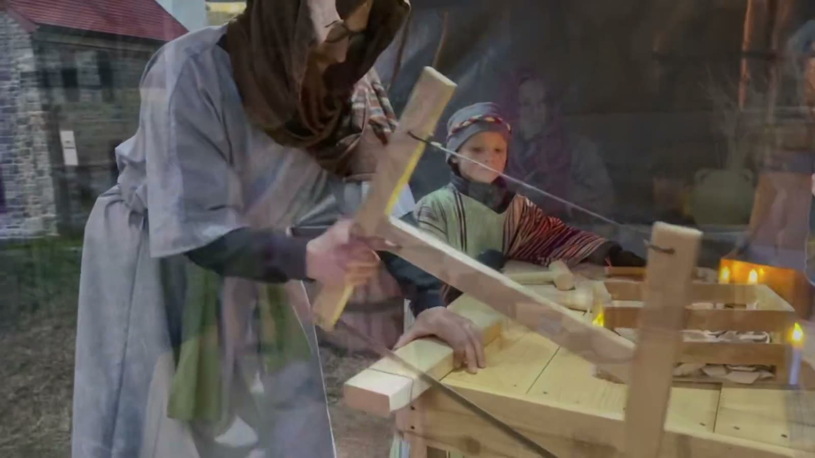 A carpenter planes a wooden frame at his bench